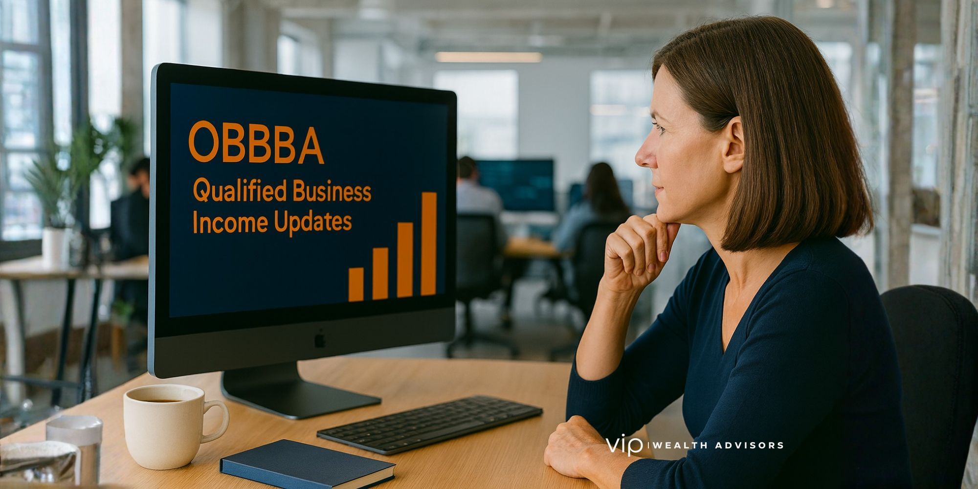 Computer engineer reviewing OBBBA Qualified Business Income (QBI) changes on a laptop in a modern office